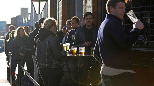 After-work drinkers enjoy a pint outside a pub in Borough Market, in London on September 25, 2020, as new earlier closing times for pubs and bars in England and Wales are introduced to combat the spread of the coronavirus. - Sputnik International