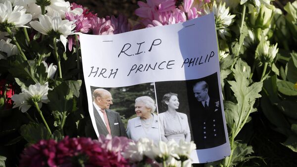 A message is left amoungst flowers outside Windsor Castle in Windsor, England Sunday, April 11, 2021. Britain's Prince Philip, the irascible and tough-minded husband of Queen Elizabeth II who spent more than seven decades supporting his wife in a role that mostly defined his life, died on Friday.  - Sputnik International