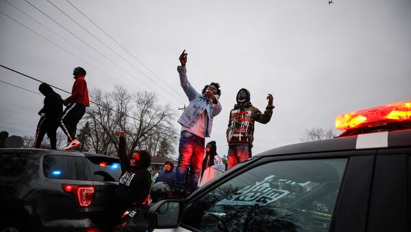 Demonstrators stand on a police vehicle during a protest after police allegedly shot and killed a man, who local media report is identified by the victim's mother as Daunte Wright, in Brooklyn Center, Minnesota, U.S. - Sputnik International