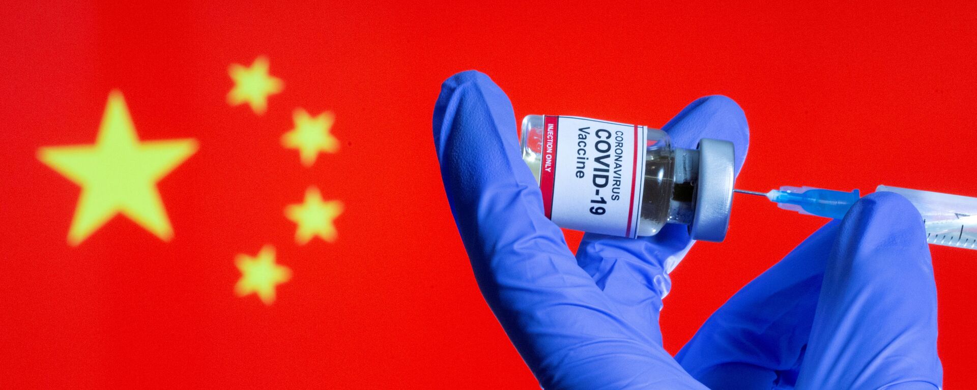 FILE PHOTO: FILE PHOTO: A woman holds a small bottle labeled with a Coronavirus COVID-19 Vaccine sticker and a medical syringe in front of displayed China flag in this illustration taken, October 30, 2020 - Sputnik International, 1920