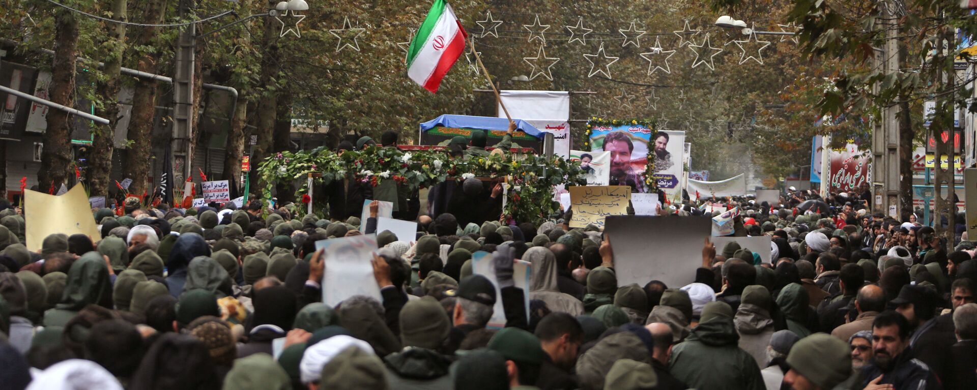 Iranian mourners attend the funeral of Morteza Ebrahimi, a commander of the Islamic Revolutionary Guard Corps, who was killed in violent demonstrations that erupted across Iran last week against a surprise petrol price hike, on November 20, 2019 in the central Iranian city of Shahriar. - Sputnik International, 1920, 26.10.2022