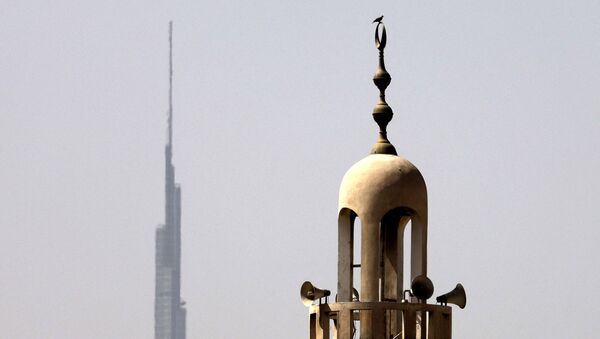 Burj Khalifa, the world's tallest tower, is silhouetted in the background of a mosque's minaret in Dubai in the United Arab Emirates, ahead of the Muslim fasting month, on April 12, 2021. - Sputnik International