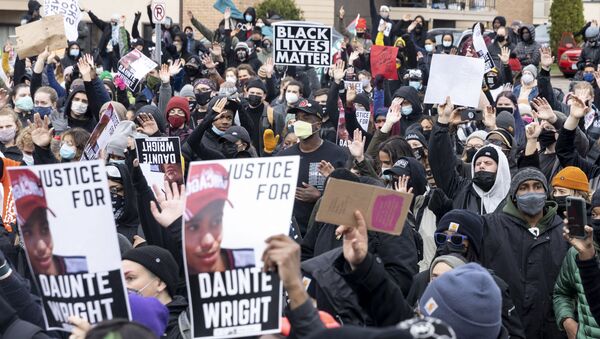 People gather before curfew holding pictures of Daunte Wright along with Black Lives Matter signs to protest his death by a police officer in Brooklyn Center, Minnesota on April 12, 2021.  - Sputnik International