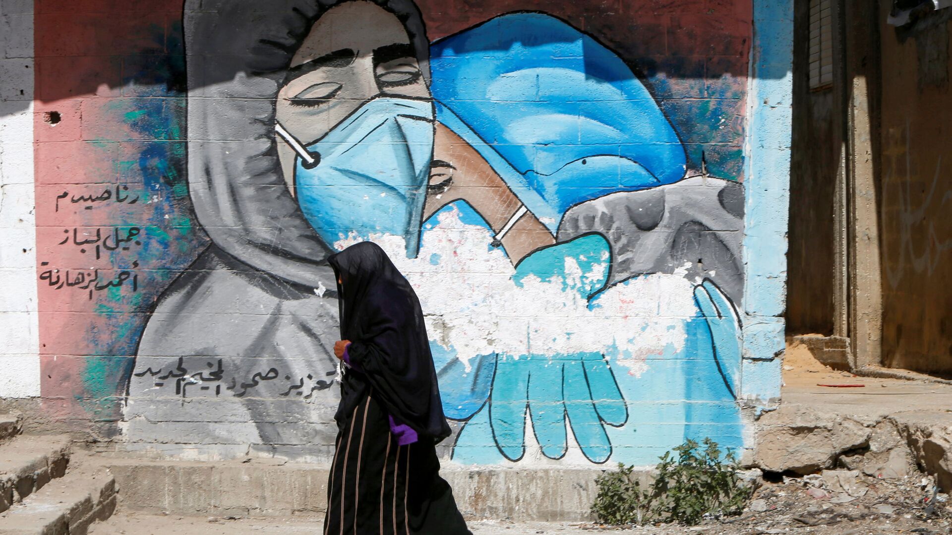A Palestinian woman walks past a mural, amid the coronavirus disease (COVID-19) outbreak, in the central Gaza Strip March 17, 2021. Picture taken March 17, 2021 - Sputnik International, 1920, 11.10.2021