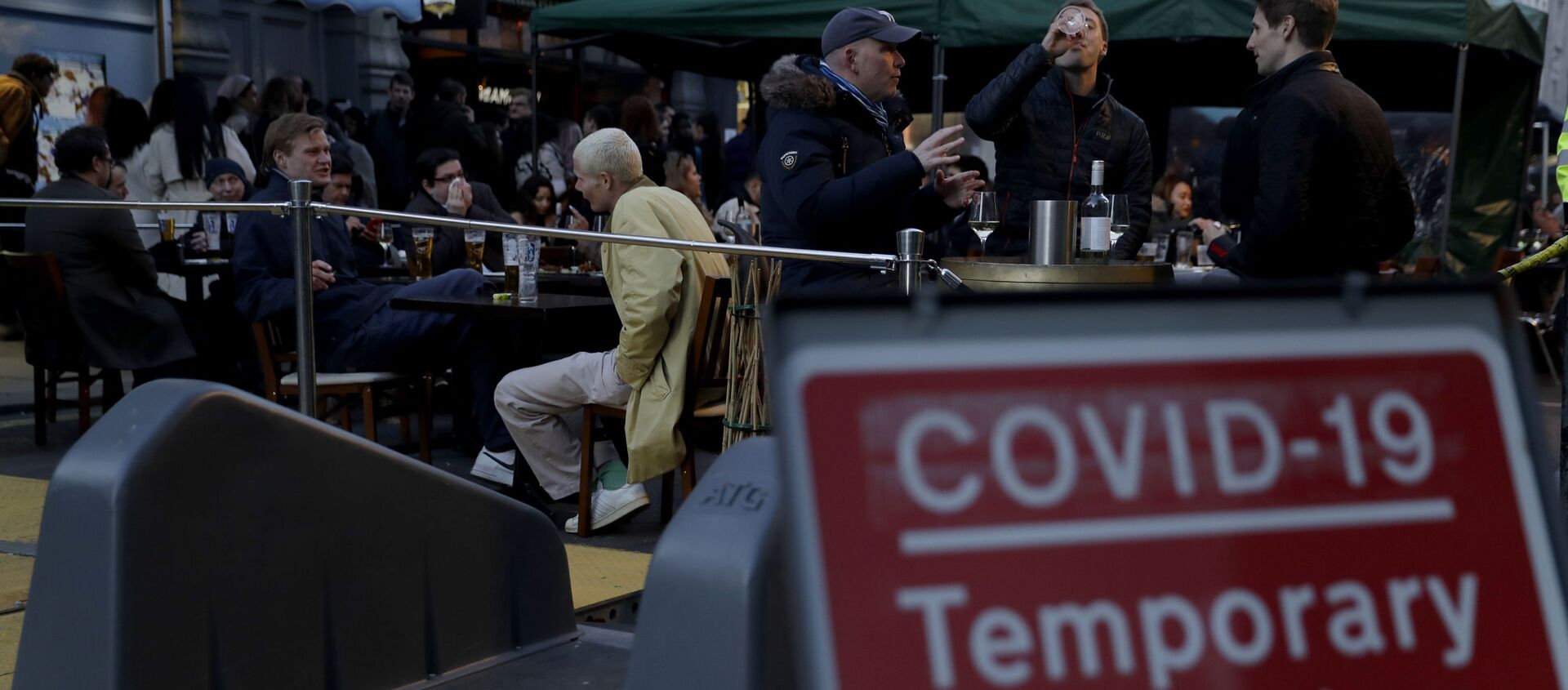 People sit at outdoor tables setup today for drinks to be served in the Soho area of central London, on the day some of England's third coronavirus lockdown restrictions were eased by the British government, Monday, April 12, 2021 - Sputnik International, 1920, 13.04.2021