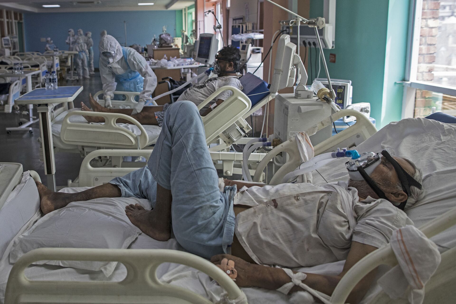 In this photograph taken on July 15, 2020 COVID-19 coronavirus patients rest on their beds at the Intensive Care Unit of the Sharda Hospital, in Greater Noida. - Sputnik International, 1920, 07.09.2021