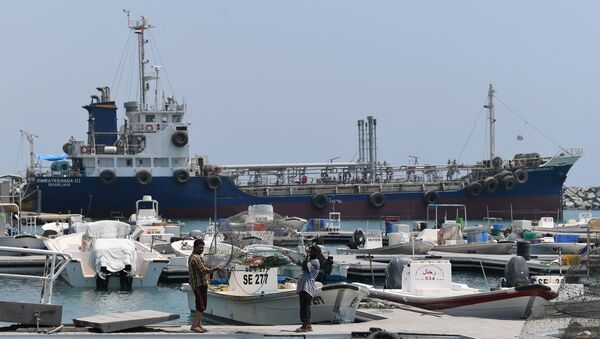 Fishermen check their net in front of ships docked in the port of Fujairah  - Sputnik International