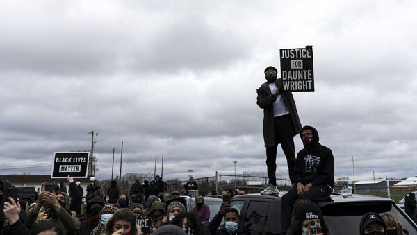 People gather holding signs and flags before curfew to protest the death of Daunte Wright who was shot and killed by a police officer in Brooklyn Center, Minnesota on April 12, 2021. - Sputnik International
