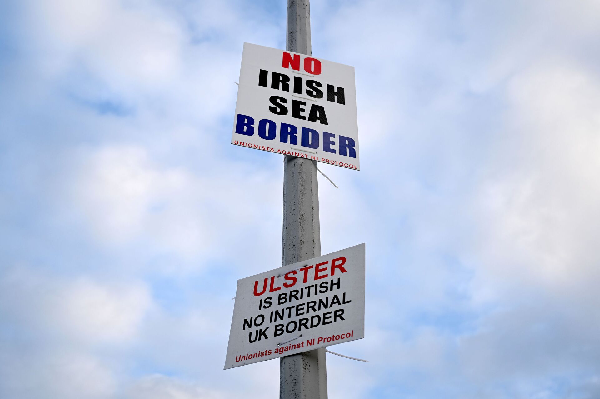 Signs reading 'No Irish Sea border' and 'Ulster is British, no internal UK Border' are seen affixed to a lamp post at the Port of Larne, Northern Ireland, March 6, 2021. Picture taken March 6, 2021 - Sputnik International, 1920, 14.09.2021