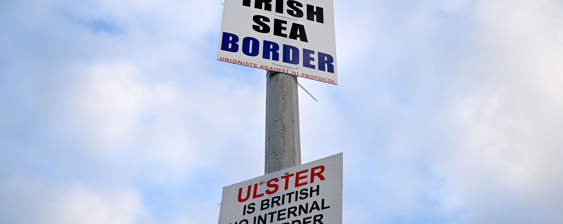Signs reading 'No Irish Sea border' and 'Ulster is British, no internal UK Border' are seen affixed to a lamp post at the Port of Larne, Northern Ireland, March 6, 2021. Picture taken March 6, 2021 - Sputnik International, 1920, 14.04.2021