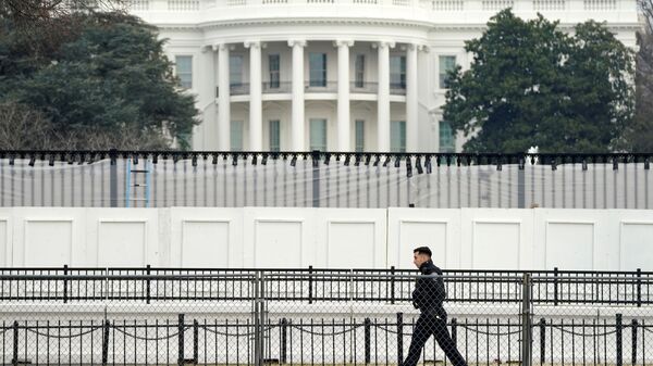 A member of the Secret Service walks along security fence installed around the White House days after supporters of U.S. President Donald Trump stormed the Capitol in Washington, U.S., January 11, 2021. - Sputnik International