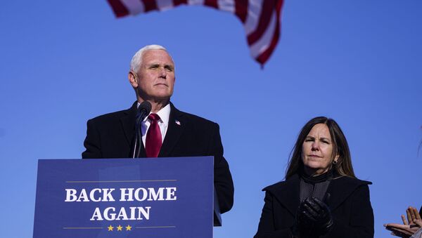 In this Jan. 20, 2021, file phot, former Vice President Mike Pence speaks after arriving back in his hometown of Columbus, Ind., as his wife Karen watches. - Sputnik International