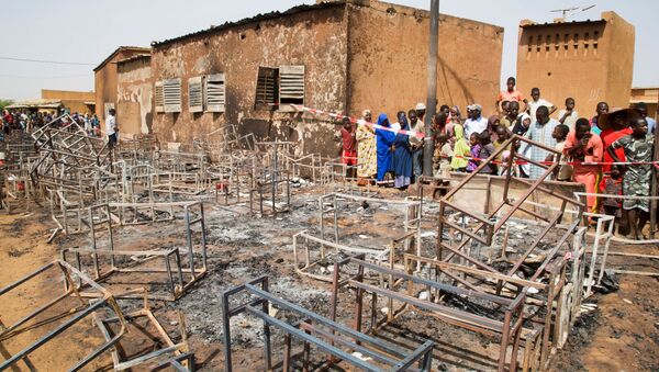 People stand next to the remains of the burnt nursery school in Niamey, Niger April 14, 2021 - Sputnik International