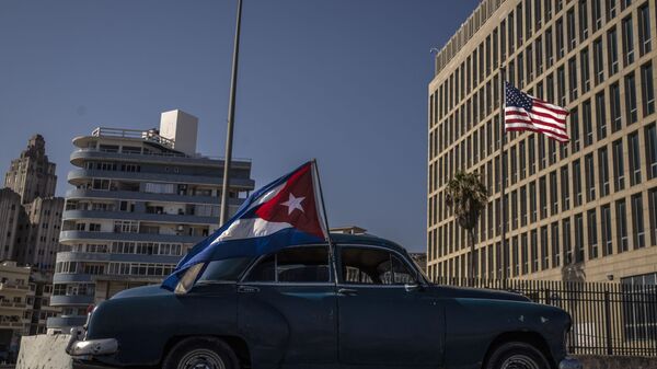 A classic American car flying a Cuban flag drives past the American embassy during a rally calling for the end of the US blockade against the island nation, in Havana, Cuba, Sunday, March 28, 2021. - Sputnik International