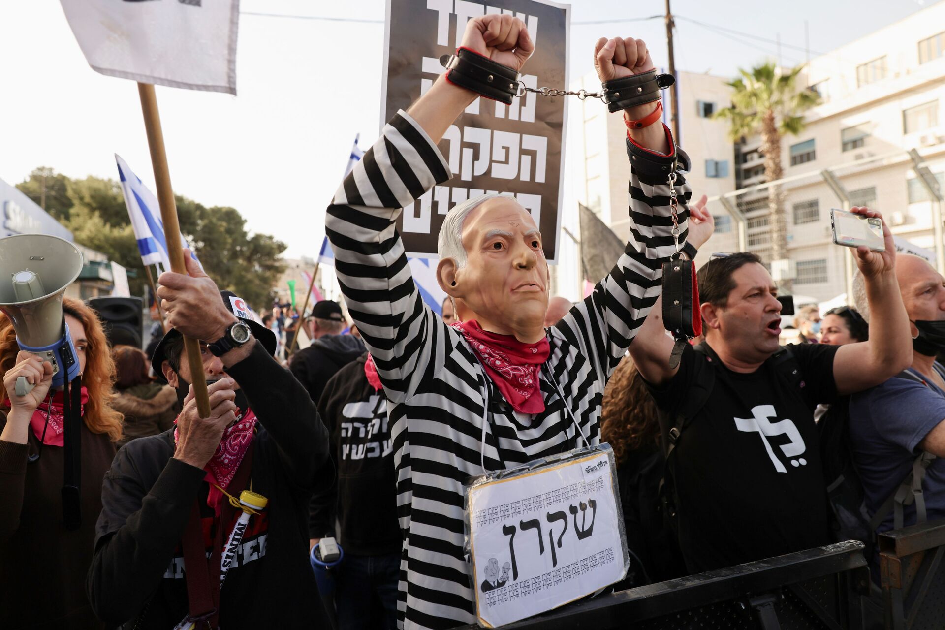 A protester wearing a mask depicting Israeli Prime Minister Benjamin Netanyahu and a sign with the word Liar in Hebrew, gestures during a demonstration against Netanyahu before his corruption trial resumes, near Jerusalem's District Court April 5, 2021. - Sputnik International, 1920, 07.09.2021