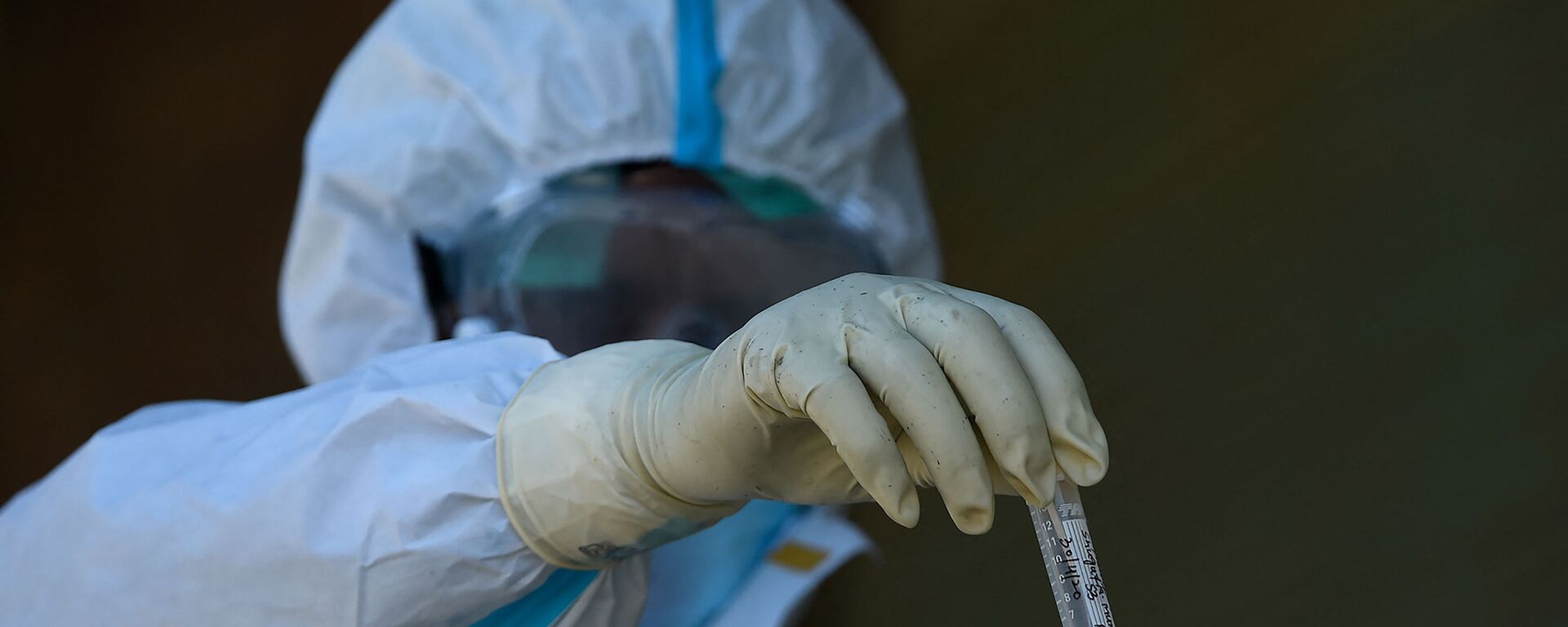 A doctor wearing a hazmat suit holds a tube containig a sample for testing the COVID-19 coronavirus during a government-imposed nationwide lockdown as a preventive measure against the COVID-19 coronavirus, in Srinagar on April 30, 2020.  - Sputnik International, 1920