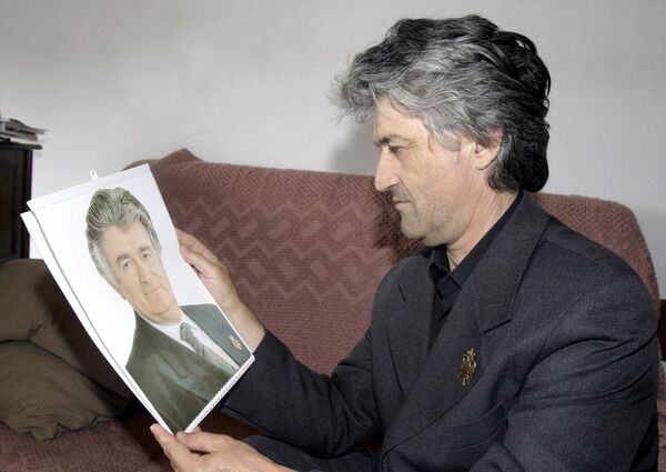 Petar Cikic, 47-year-old Bosnian Serb looks at the photo of Radovan Karadzic  - Sputnik International