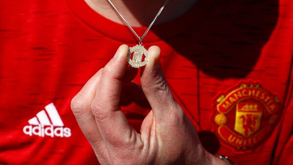 A Manchester United fan holds their Manchester United logo necklace outside Old Trafford as twelve of Europe's top football clubs launch a breakaway Super League - Manchester, Britain - April 19, 2021 - Sputnik International