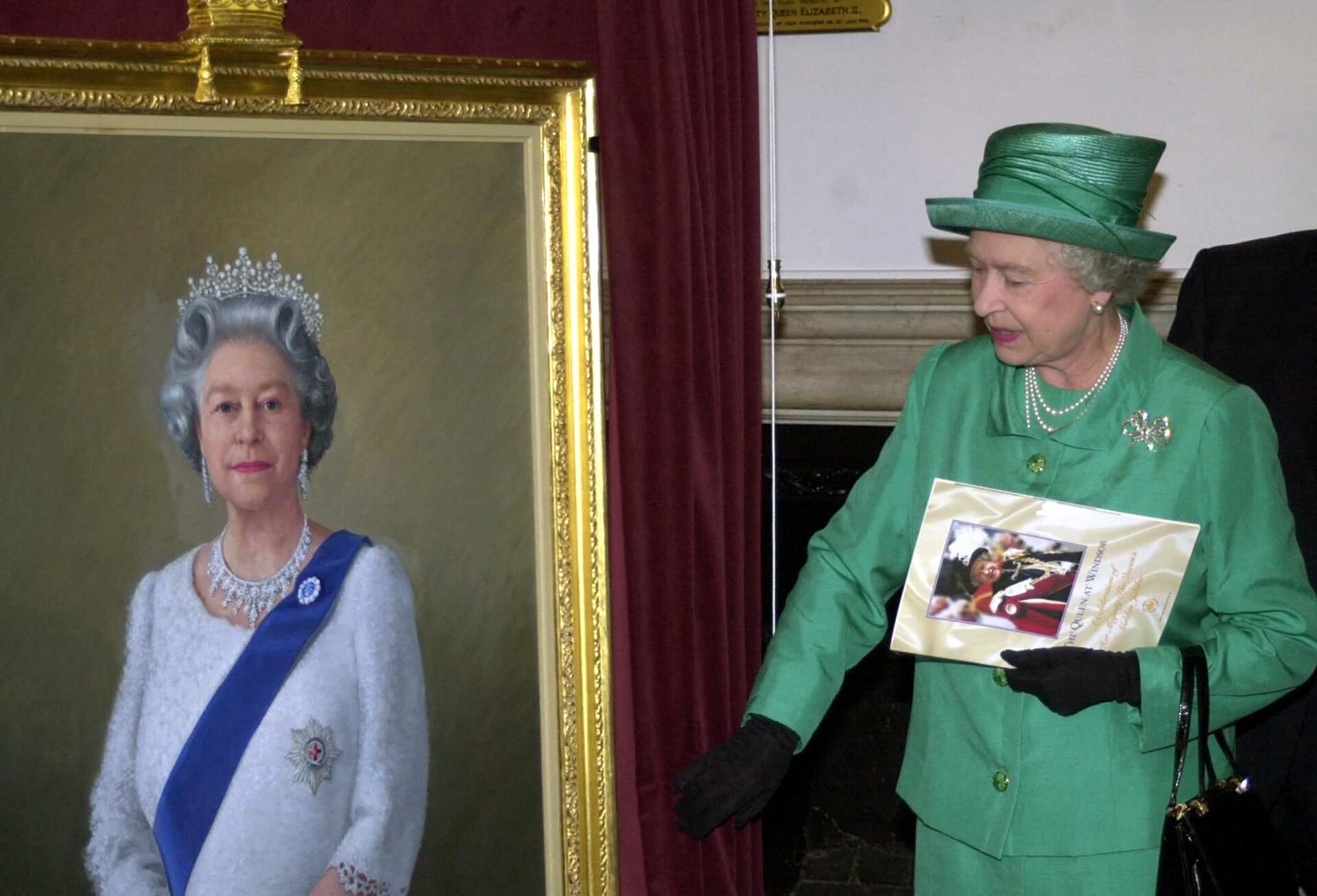 Queen Elizabeth II unveils a portrait of herself by artist Theodore Ramos at the Guildhall in Windsor, 03 June 2002, to mark her Golden Jubilee. A 1954 painting of the Queen hangs on the wall in the background - Sputnik International, 1920, 15.11.2021