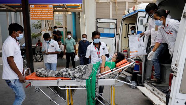 A patient wearing an oxygen mask is wheeled inside a COVID-19 hospital for treatment, amidst the spread of the coronavirus disease (COVID-19) in Ahmedabad, India, April 21, 2021. - Sputnik International