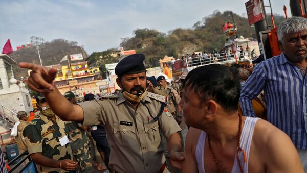 A police officer asks a devotee to leave after he took a holy dip in the waters of river Ganges during Kumbh Mela, or the Pitcher Festival, amidst the spread of the coronavirus disease (COVID-19), in Haridwar, India, April 12, 2021.  - Sputnik International