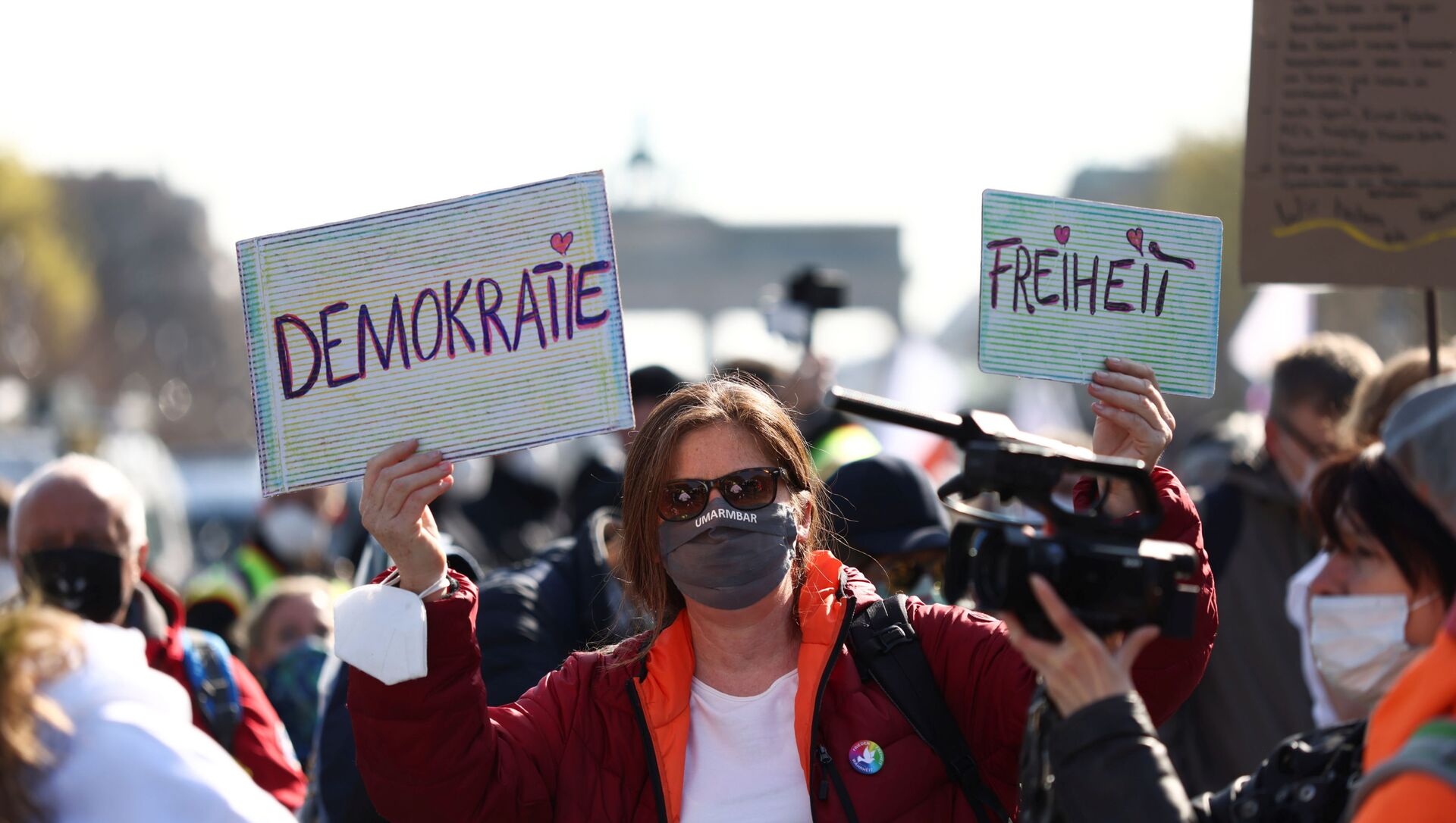 A demonstrator holds up signs reading democracy and freedom during a protest against the government measures to curb the spread of the coronavirus disease (COVID-19), on the day of discussion in the lower house of parliament Bundestag regarding additions for the Infection Protection Act, in Berlin, Germany April 21, 2021 - Sputnik International, 1920, 21.04.2021