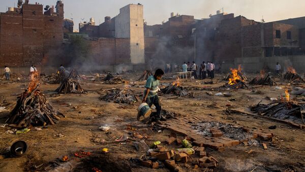 Funeral pyres of people, who died due to the coronavirus disease (COVID-19), are pictured at a crematorium ground in New Delhi, India, April 22, 2021 - Sputnik International