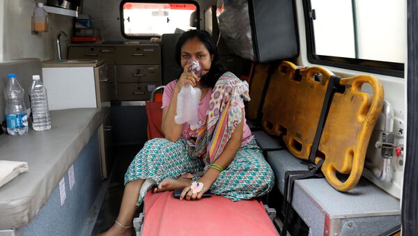 A patient with respiratory problems wears an oxygen mask as she waits inside an ambulance which is queuing to enter a COVID-19 hospital, as the coronavirus disease pandemic surges, Ahmedabad, India, 14 April 2021. - Sputnik International