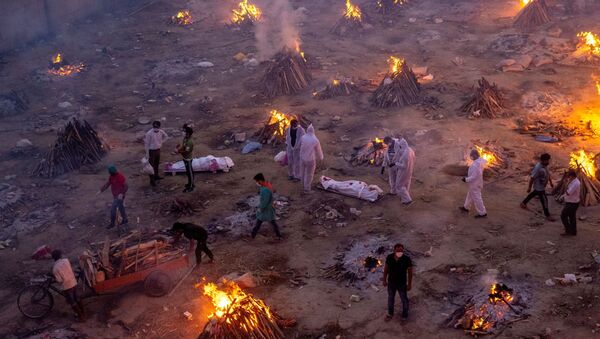 People wait to cremate COVID-19 victims at a crematorium ground in New Delhi - Sputnik International