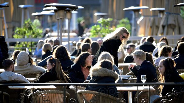 FILE PHOTO: People enjoy the sun at an outdoor restaurant, despite the continuing spread of coronavirus disease (COVID-19), in Stockholm, Sweden March 26, 2020.  - Sputnik International