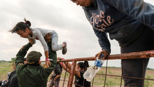 Central American migrants climb over a fence as they are detained by U.S. Border Patrol agents after crossing the Rio Grande river into the United States from Mexico in La Joya, Texas, U.S.,  April 27, 2021. - Sputnik International