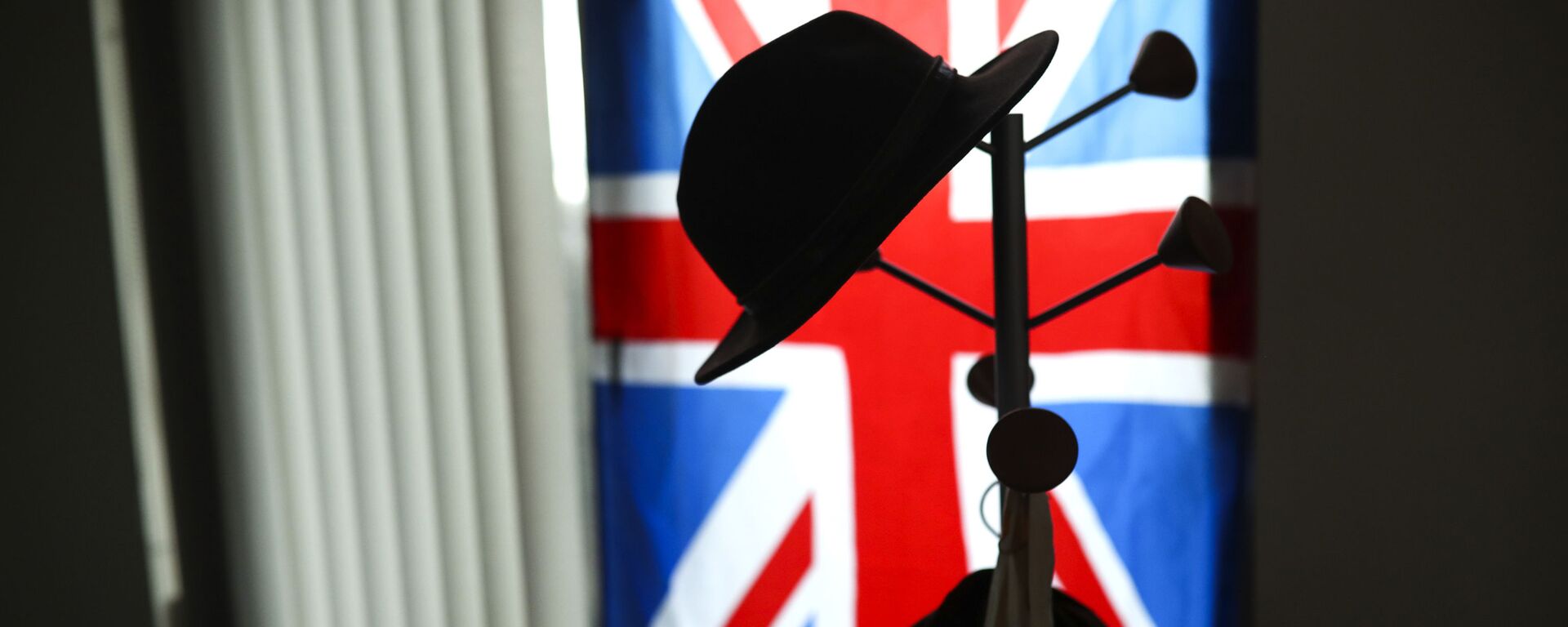 A hat hangs on a coat stand in front of the Union flag (File) - Sputnik International, 1920, 20.05.2021