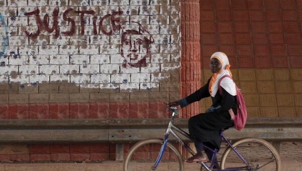 A girl rides a bicycle past graffiti reading Justice with a picture of slain ex-President Thomas Sankara in Ouagadougou, Burkina Faso, December 4, 2015. - Sputnik International