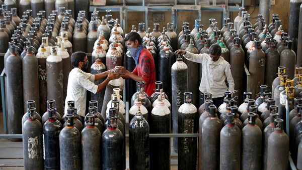 People carry oxygen cylinders after refilling them in a factory, amidst the spread of the coronavirus disease (COVID-19) in Ahmedabad, India, April 25, 2021 - Sputnik International