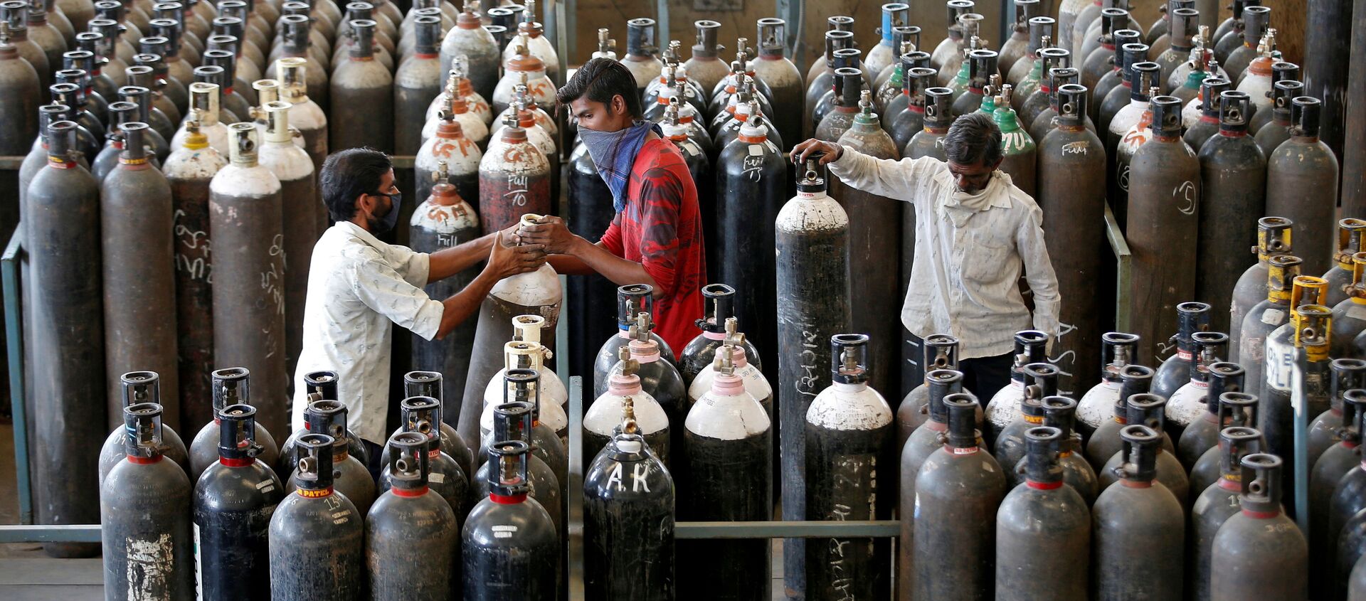 People carry oxygen cylinders after refilling them in a factory, amidst the spread of the coronavirus disease (COVID-19) in Ahmedabad, India, April 25, 2021 - Sputnik International, 1920
