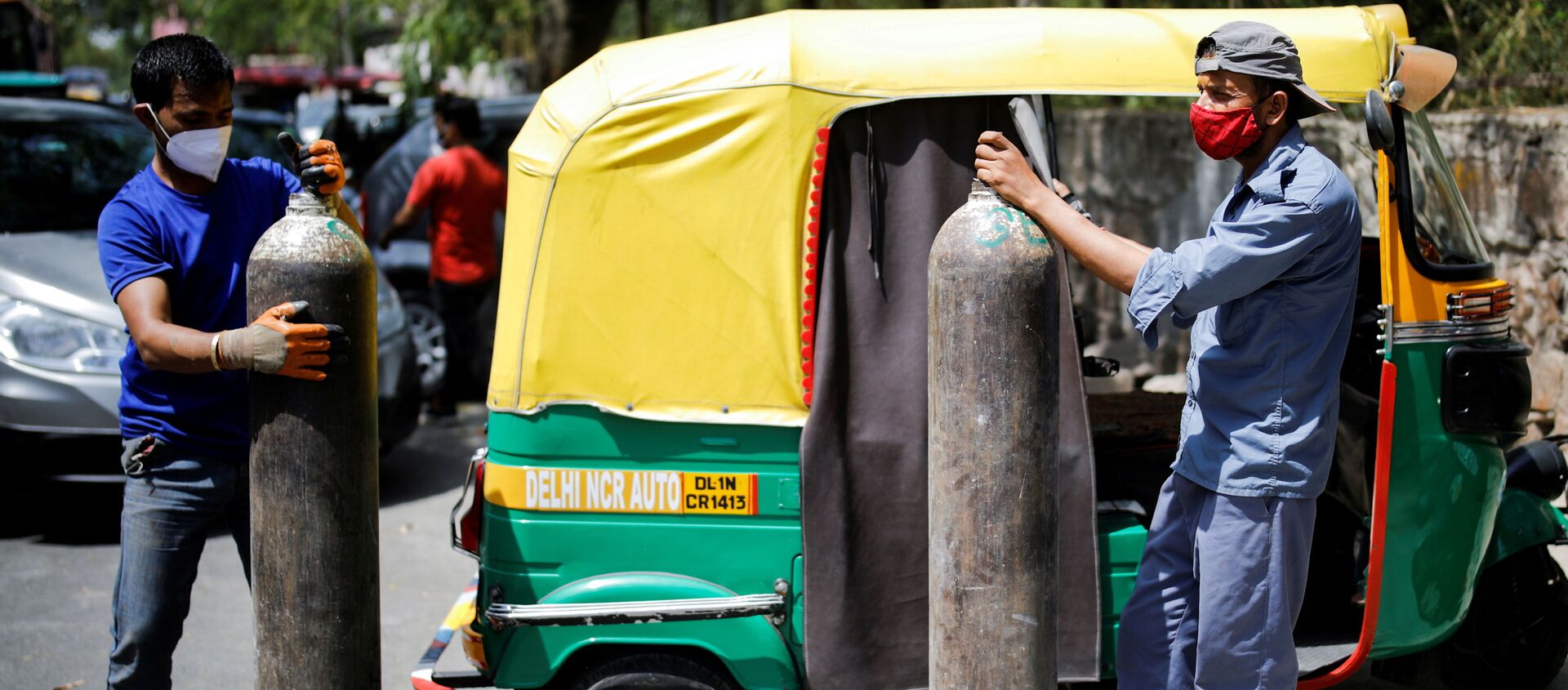  Rickshaw drivers hold oxygen cylinders outside a private refilling station, amid the coronavirus disease (COVID-19) outbreak, in New Delhi, India, April 19, 2021 - Sputnik International, 1920