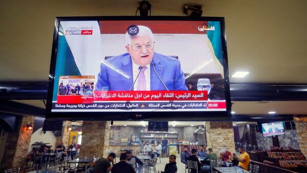A screen displaying a live broadcast of Palestinian President Mahmoud Abbas's speech during a meeting to discuss upcoming elections, is seen in a coffee shop in Ramallah in the Israeli-occupied West Bank April 29, 2021. - Sputnik International
