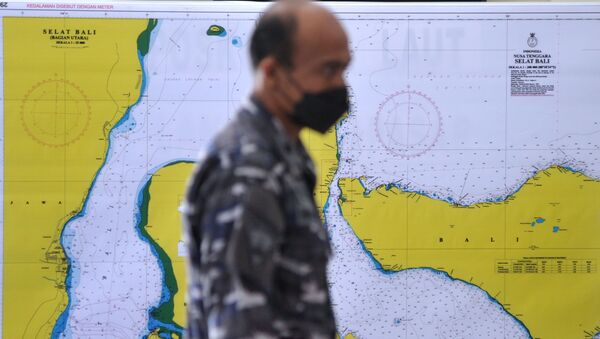 An Indonesian Navy serviceman walks past a map of the searching area for the submarine KRI Nanggala-402, which lost contact while drilling torpedo shooting on Wednesday, at I Gusti Ngurah Rai airport in Bali, Indonesia, 23 April 2021 in this photo taken by Antara Foto - Sputnik International