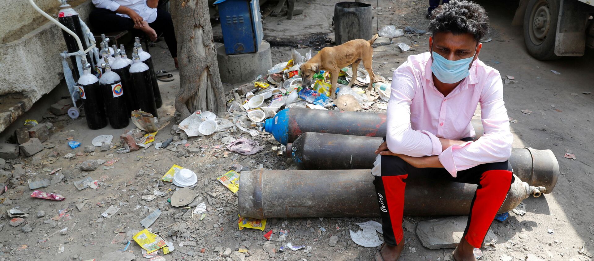 Sumit Kumar, 28, sits on an oxygen cylinder as he waits outside a factory to get it refilled, as the number of infections from the coronavirus disease (COVID-19) soars in New Delhi, India. - Sputnik International, 1920, 30.04.2021