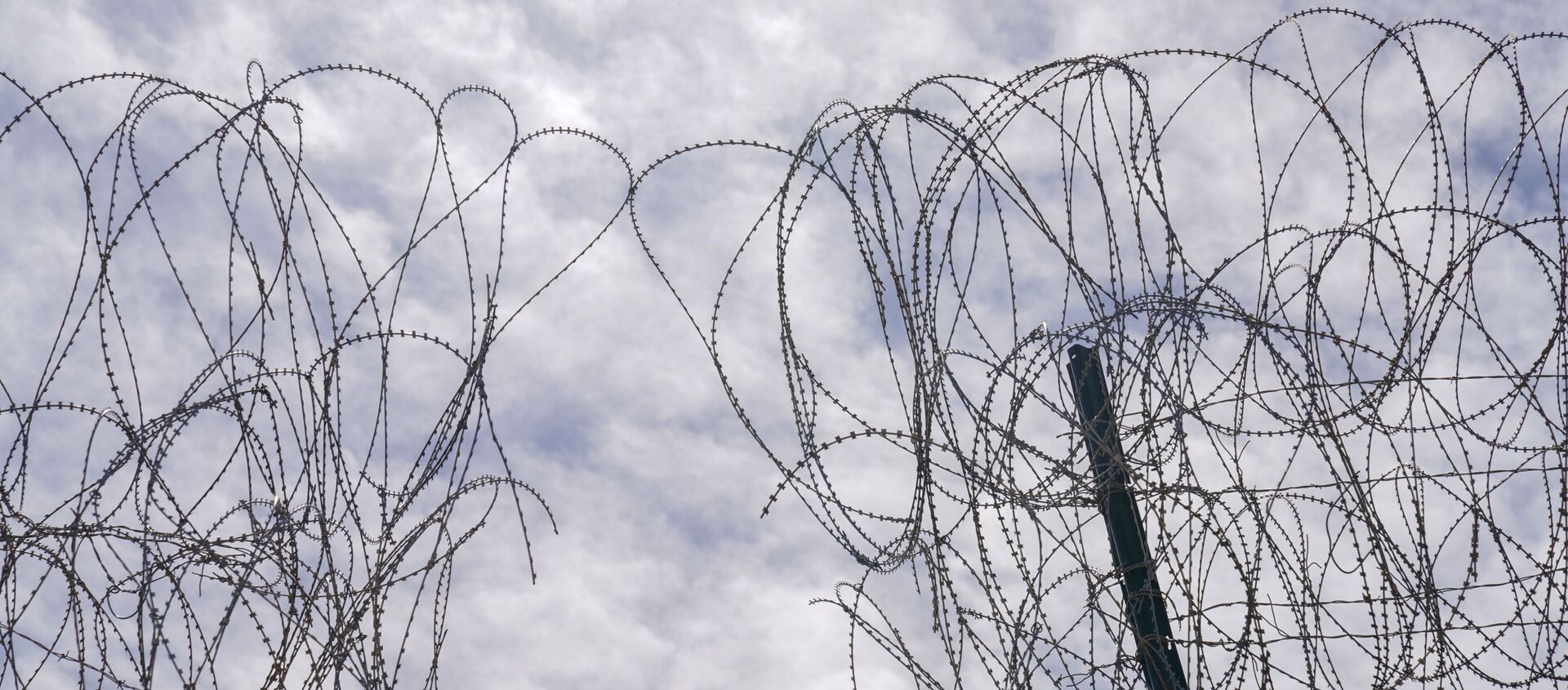 A section of the U.S. border wall razor wire cut by asylum-seeking migrants is seen in Calexico, California, U.S., April 8, 2021. - Sputnik International, 1920, 30.04.2021
