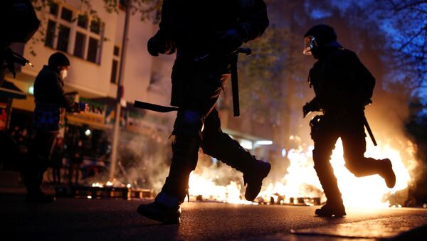 Police officers run past a fire during a left-wing May Day demonstration, as the spread of the coronavirus disease (COVID-19) continues in Berlin, Germany, May 1, 2021. - Sputnik International