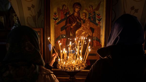 Women light candles in front of an icon on the eve of Orthodox Easter in the Joseph-Volokolamsk monastery in Moscow region, Russia May 1, 2021. - Sputnik International