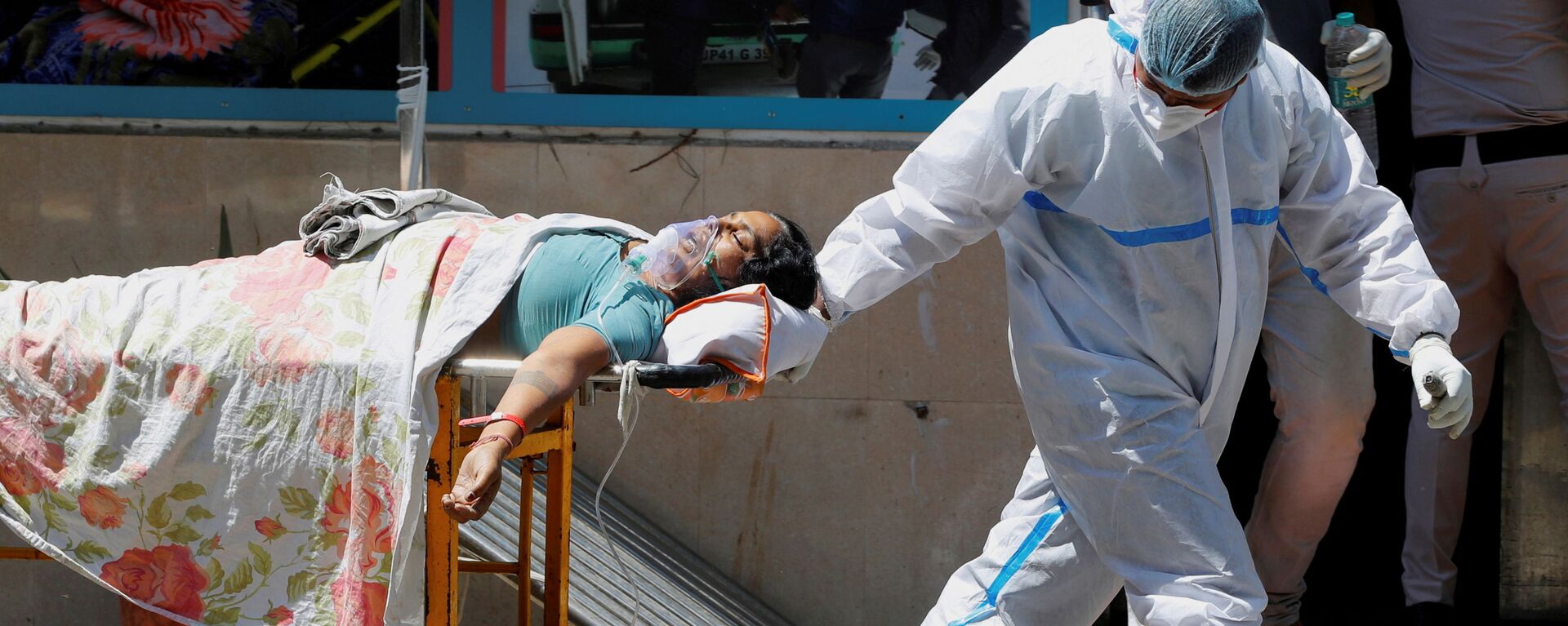 FILE PHOTO: A health worker wearing personal protective equipment (PPE) carries a patient suffering from the coronavirus disease (COVID-19) outside the casualty ward at Guru Teg Bahadur hospital, in New Delhi, India, April 24, 2021. - Sputnik International, 1920