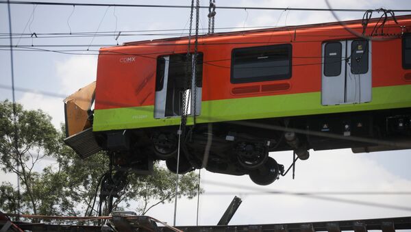 Workers move a train car from a site where an overpass for a metro partially collapsed with train cars on it at Olivos station in Mexico City, Mexico May 4, 2021 - Sputnik International