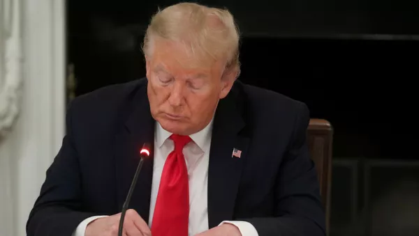 U.S. President Donald Trump is seen tapping the screen on a mobile phone during a roundtable discussion on the reopening of small businesses in the State Dining Room at the White House in Washington, U.S., June 18, 2020 - Sputnik International