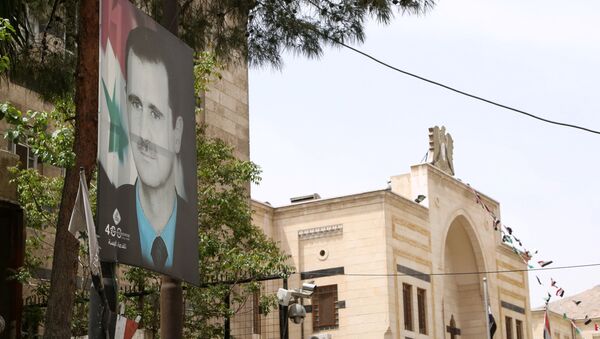 A picture of Syria's President Bashar al-Assad is pictured outside the parliament building in Damascus, Syria April 18, 2021.  - Sputnik International