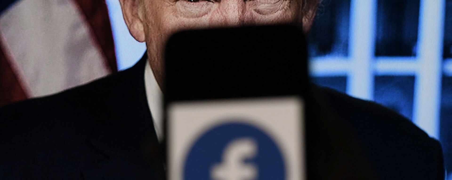 In this photo illustration, a phone screen displays a Facebook logo with the official portrait of former US President Donald Trump on the background, on May 4, 2021, in Arlington, Virginia. - Facebook's independent oversight board was set for a momentous decision on the platform's ban of former US president Donald Trump, as debate swirls on the role of social media in curbing hateful and abusive speech while controlling political discourse. - Sputnik International, 1920, 18.01.2023