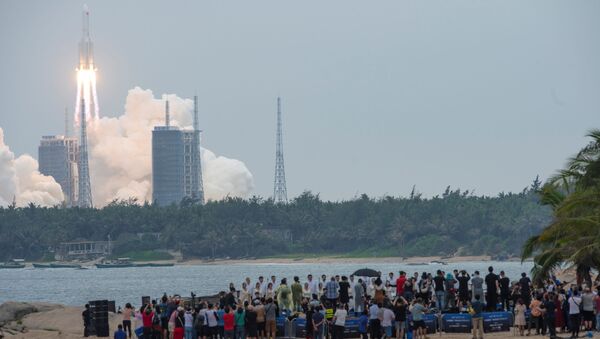 People watch from a beach as the Long March-5B Y2 rocket, carrying the core module of China's space station Tianhe, takes off from Wenchang Space Launch Center in Hainan province, China April 29, 2021.  - Sputnik International