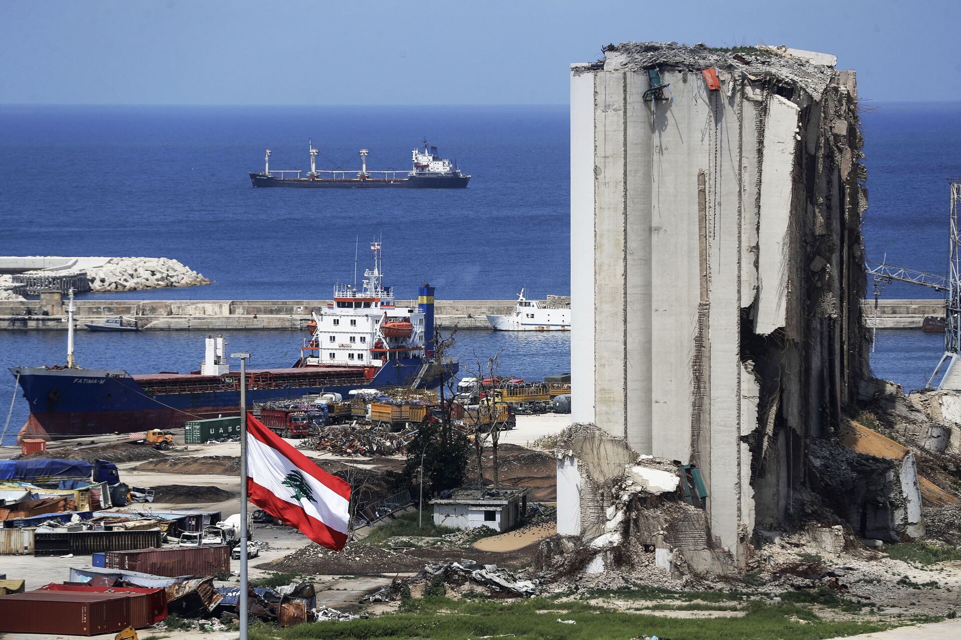A picture shows a view of the damaged grain silos at the port of the Lebanese capital Beirut, on April 9, 2021, still reeling from the destruction due to a catastrophic blast in a harbour storage unit last August that killed more than 200 people and damaged swathes of the capital, with the Togo-flagged Fatima M bulk carrier ship moored nearby.  - Sputnik International, 1920, 04.08.2022