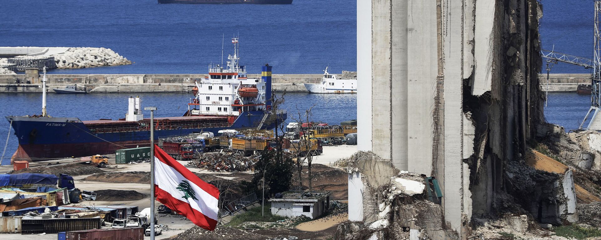 A picture shows a view of the damaged grain silos at the port of the Lebanese capital Beirut, on April 9, 2021, still reeling from the destruction due to a catastrophic blast in a harbour storage unit last August that killed more than 200 people and damaged swathes of the capital, with the Togo-flagged Fatima M bulk carrier ship moored nearby.  - Sputnik International, 1920, 27.09.2021
